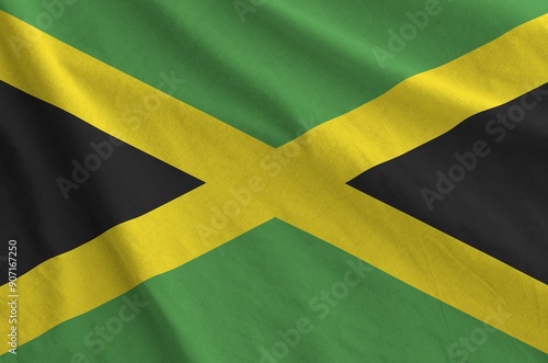 Jamaica flag depicted on folded wavy fabric of old cloth close up