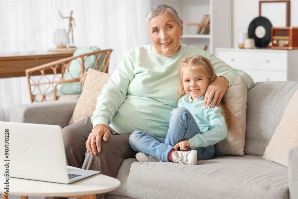 Cute little girl with her granny watching cartoons at home Cute little girl with her granny watching cartoons at home