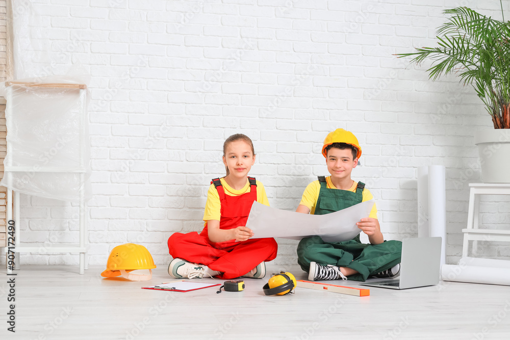 Little architects with house plan sitting in room