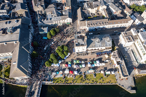 Crowded city centre during the Galway Arts Festival. Pegasus Parade concludes at the Spanish Arch. Aerial top-down view
