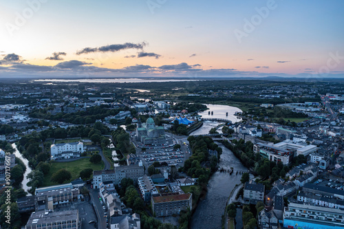 Aerial view of Galway city centre during the Pegasus Parade at twilight, showcasing the vibrant festivities and illuminated streets