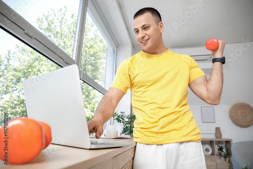 Sporty young man with dumbb...