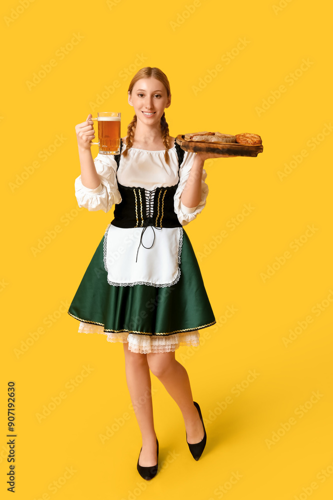 Beautiful happy Octoberfest waitress with beer and board of traditional food on yellow background Beautiful happy Octoberfest waitress with beer and board of traditional food on yellow background