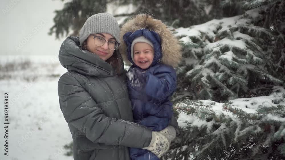A young mother with her little son in her arms A young mother with her little son in her arms