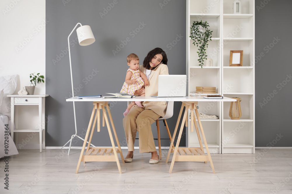 Working mother talking by mobile phone with her little baby at home