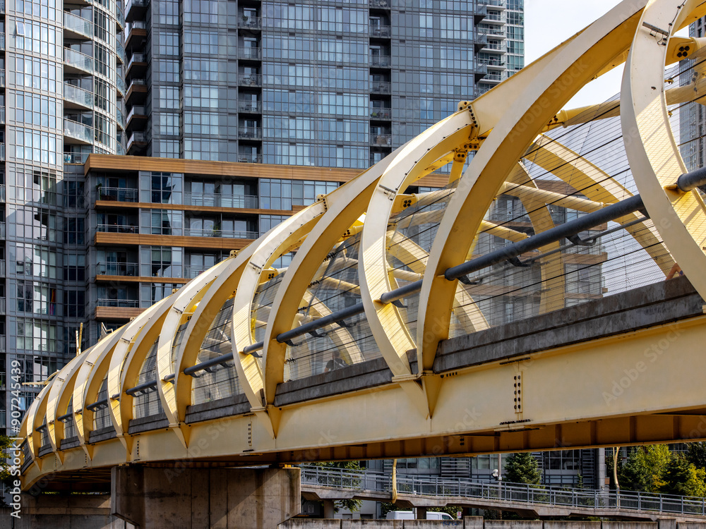 Fototapeta premium A steel beam bridge in Toronto from Front Street over the railway tracks downtown appearing as a reminder of the heavy industry that one covered to area that is now mainly condo buildings