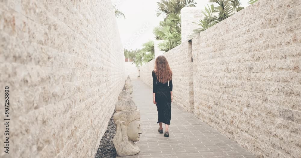 Cinematic shot of young woman walking trough the street. Bali luxury villa. Travel concept Cinematic shot of young woman walking trough the street. Bali luxury villa. Travel concept