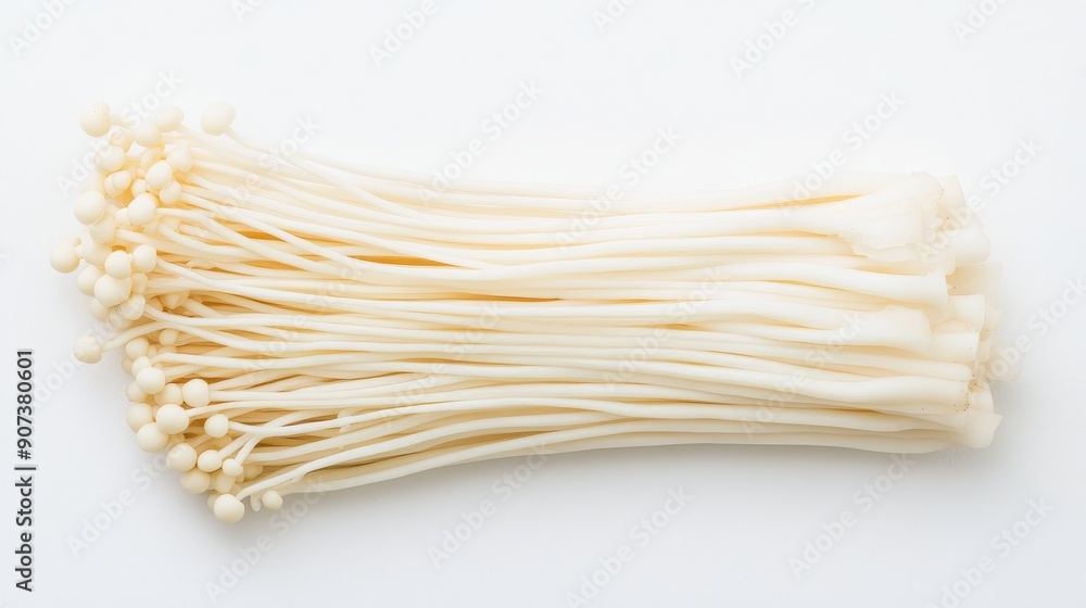 Thin slices of enoki mushrooms, showcasing their long, slender stems and tiny caps. Arranged meticulously on a stark white backdrop Thin slices of enoki mushrooms, showcasing their long, slender stems and tiny caps. Arranged meticulously on a stark white backdrop