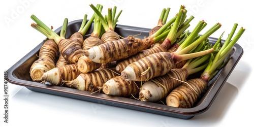 Freshly harvested organic arrowroot rhizomes on a tray, showcasing Maranta arundinacea's starchy underground stems, prized for gluten-free culinary uses, isolated on a clean white background.
