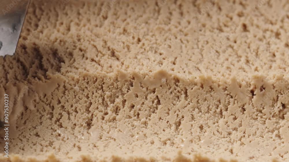 Slow motion closeup hazelnut praline ice cream scooping Slow motion closeup hazelnut praline ice cream scooping