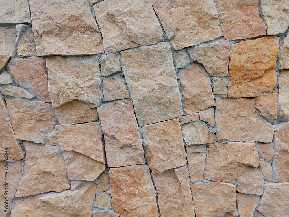 Fototapeta premium A wall of brown sandstone. The texture of a wall lined with natural stones.