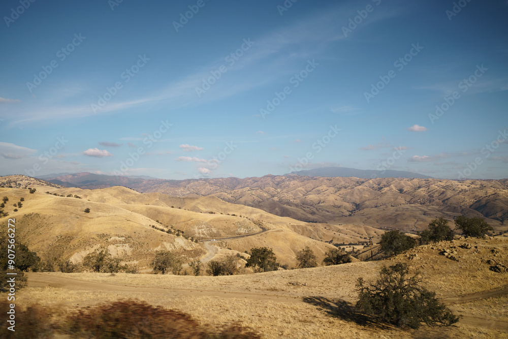Golden hills with trees and roads in clear day Golden hills with trees and roads in clear day