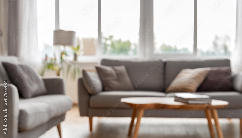 Blurred interior of light living room with grey sofas, coffee table and big window Blurred interior of light living room with grey sofas, coffee table and big window