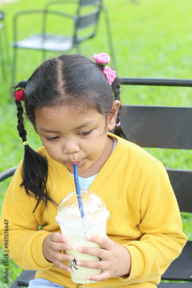 little girl is drinking from glass with straw at cafe little girl is drinking from glass with straw at cafe