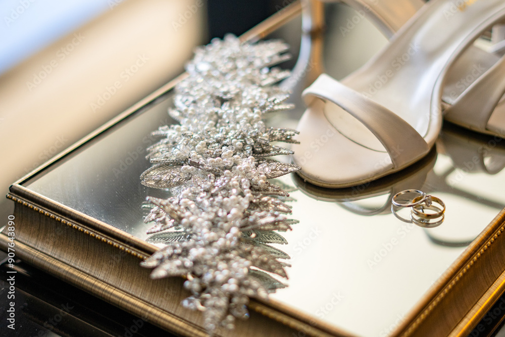 A timeless and classic bridal image featuring white shoes, gold bands, and a sparkling tiara