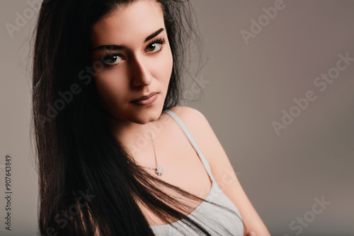 Young woman with long black hair showing serious facial expressi photo