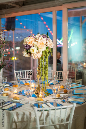 Charming Indoor Wedding Table Arrangement with White Decor and Night Cityscape