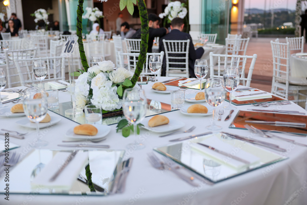 Elegant Indoor Wedding Reception with White Floral Centerpieces and Mirror Chargers