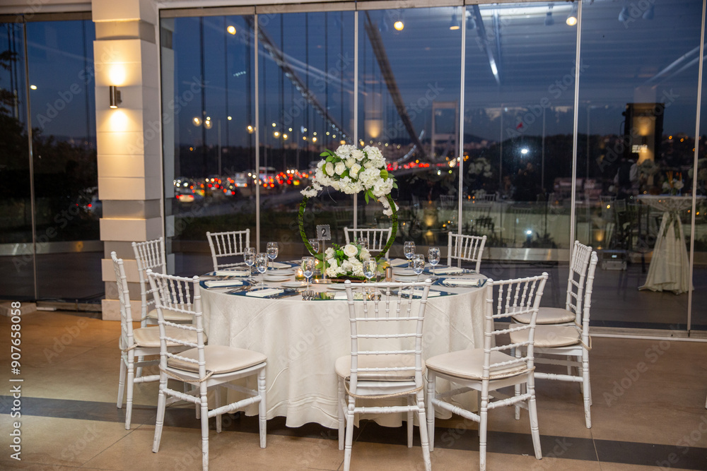 Charming Indoor Wedding Table Arrangement with White Decor and Night Cityscape