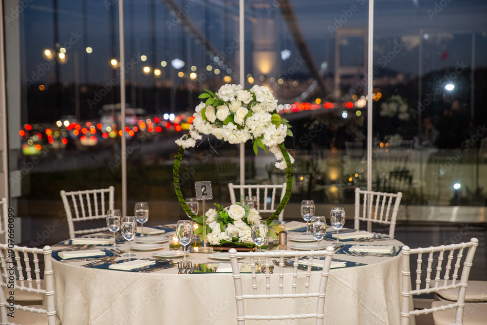 Charming Indoor Wedding Table Arrangement with White Decor and Night Cityscape