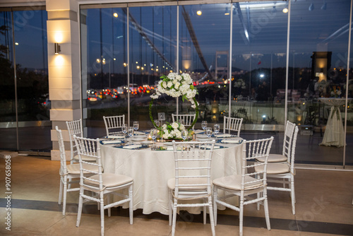 Obraz na płótnie Charming Indoor Wedding Table Arrangement with White Decor and Night Cityscape w salonie