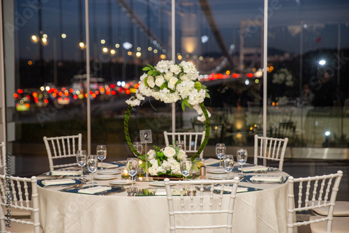 Obraz na płótnie Charming Indoor Wedding Table Arrangement with White Decor and Night Cityscape w salonie
