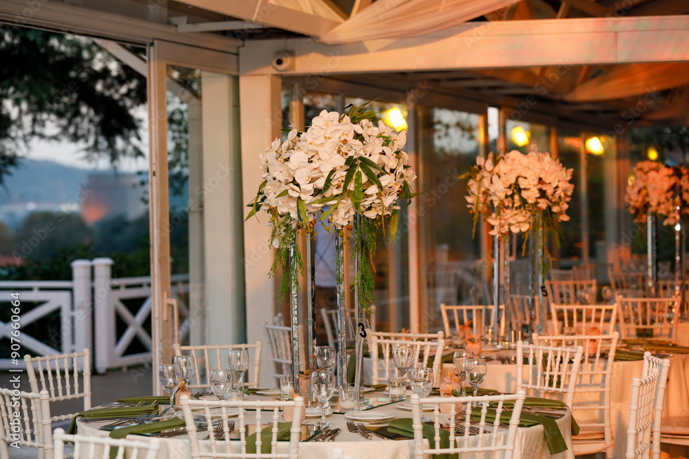 Elegant Wedding Venue with Floral Centerpieces and White Chairs