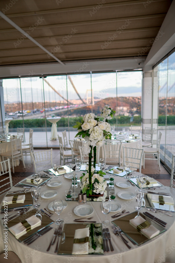 Indoor Wedding Setup: Round Tables and Floral Decor in White and Green
