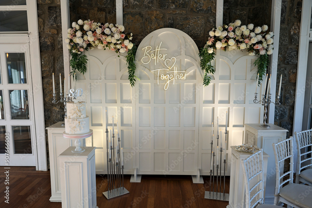 Refined Wedding Cake Presentation with Flowers and Lighting Inside Venue