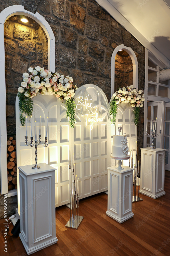Refined Wedding Cake Presentation with Flowers and Lighting Inside Venue