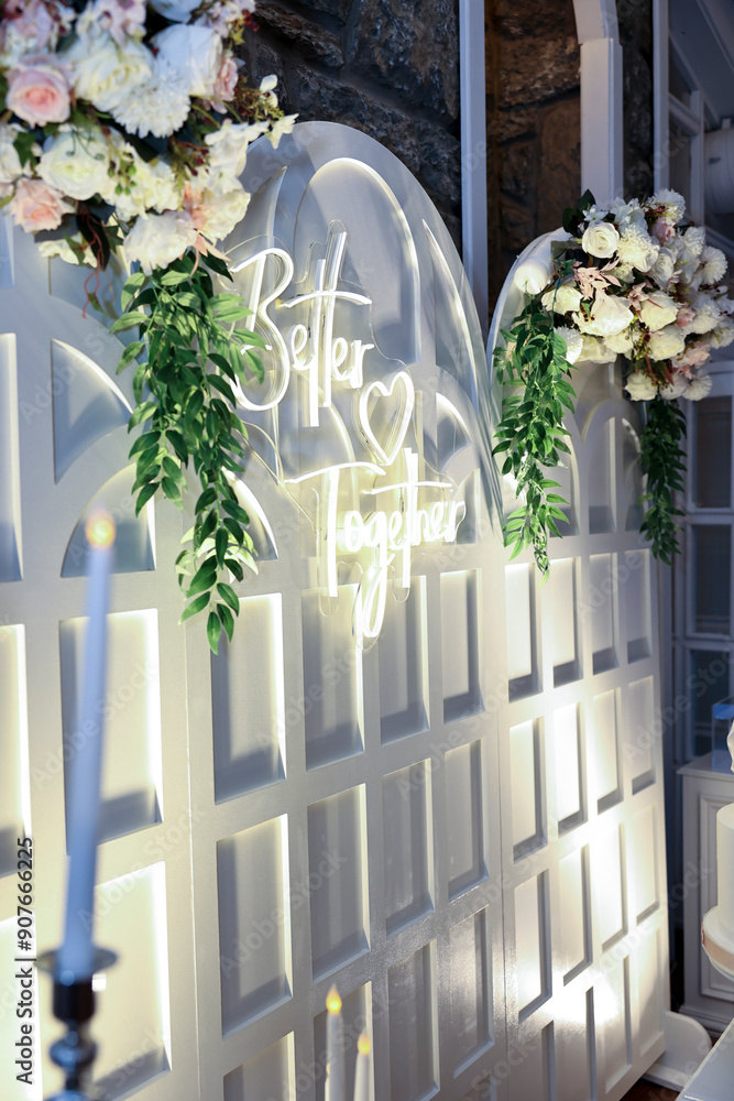 Refined Wedding Cake Presentation with Flowers and Lighting Inside Venue