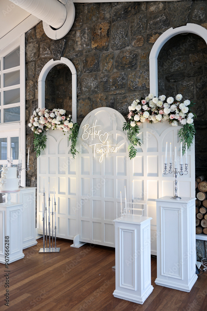 Refined Wedding Cake Presentation with Flowers and Lighting Inside Venue