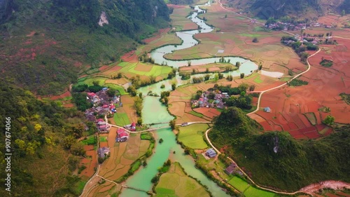 This drone footage captures the breathtaking beauty of Phong Nam Valley in Cao Bang. The video showcases a majestic winding river flowing through lush green rice fields, framed by rugged mountains. 