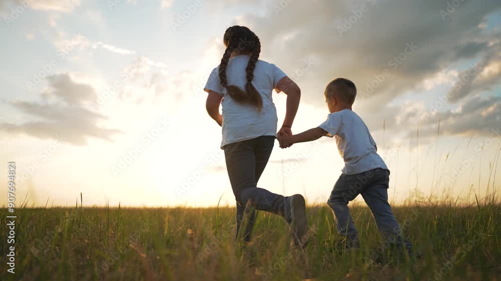 Brother sister running on grass. siblings holding hands in park at ...
