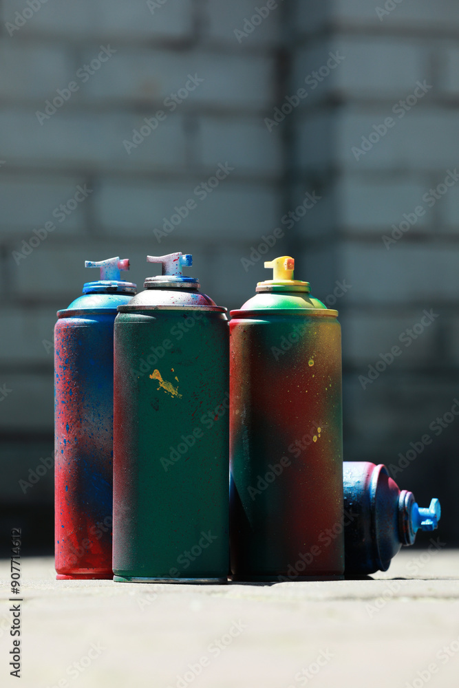Many spray paint cans outdoors on sunny day Many spray paint cans outdoors on sunny day