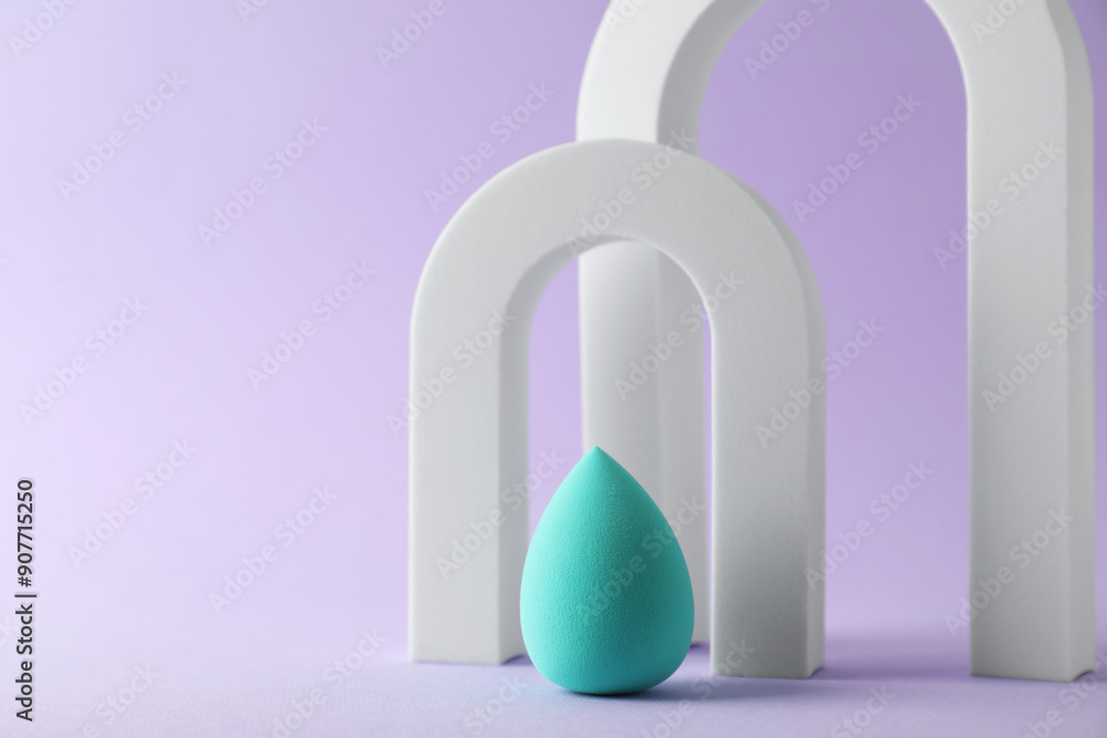 Stylish presentation of makeup sponge on violet background, space for text Stylish presentation of makeup sponge on violet background, space for text
