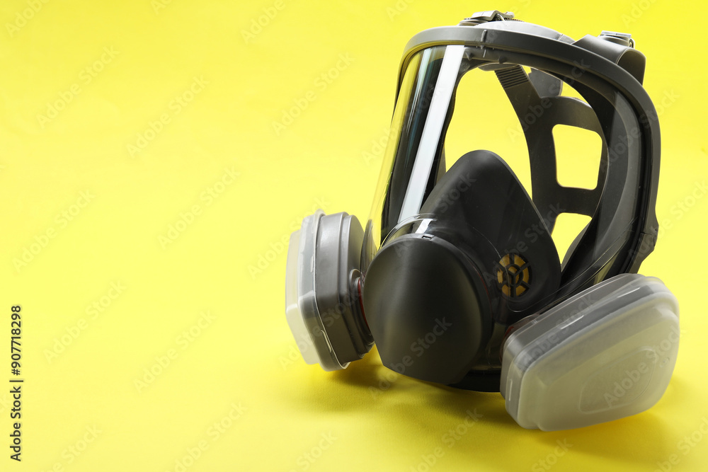 One full face respirator on yellow background, closeup. Space for text One full face respirator on yellow background, closeup. Space for text