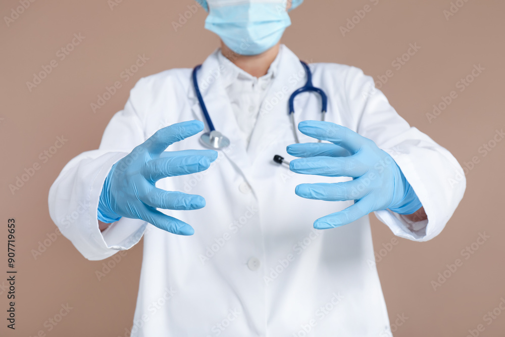 Doctor holding something on beige background, closeup Doctor holding something on beige background, closeup