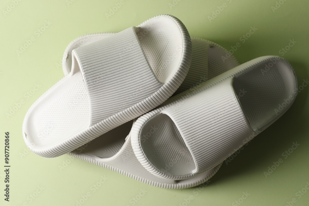 Pairs of slippers on green background, top view Pairs of slippers on green background, top view