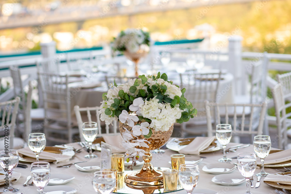 Romantic outdoor wedding with round tables, white linens, and floral centerpieces, overlooking a beautiful city view Romantic outdoor wedding with round tables, white linens, and floral centerpieces, overlooking a beautiful city view
