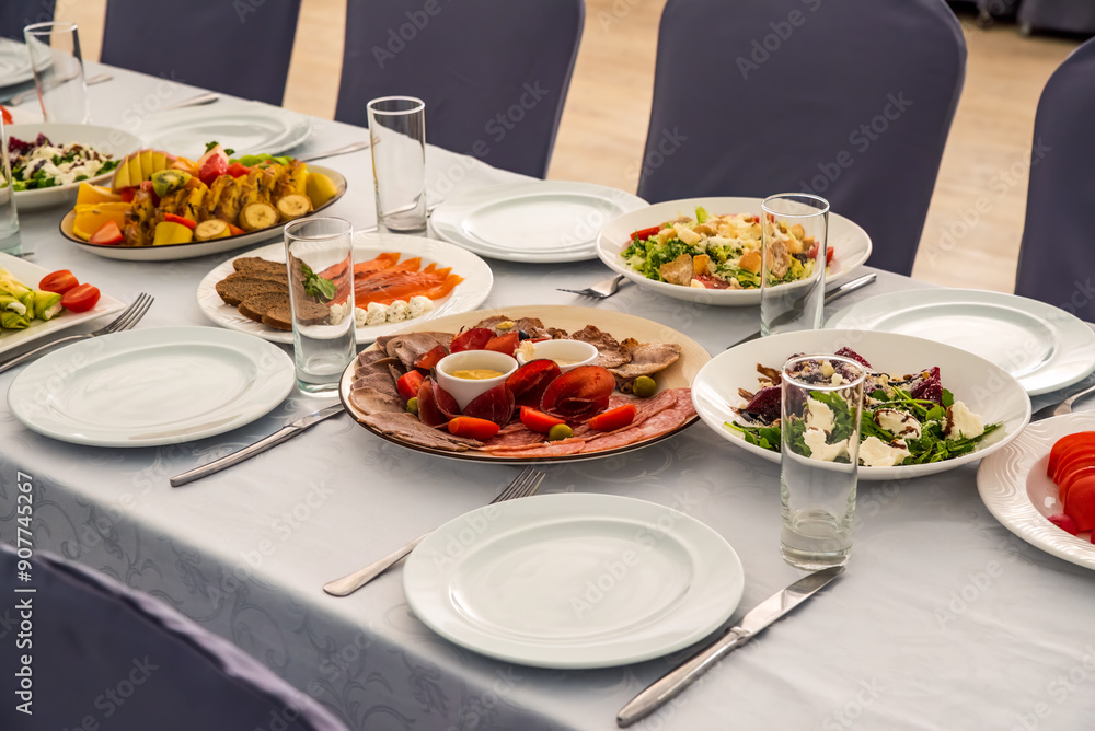festive table set with Caesar salads, beets, fruit plate without people festive table set with Caesar salads, beets, fruit plate without people