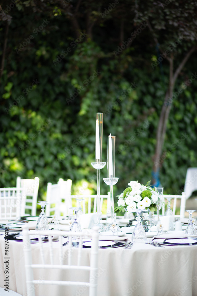 Elegantly Set Wedding Table with White Flowers and Candles at Outdoor Reception