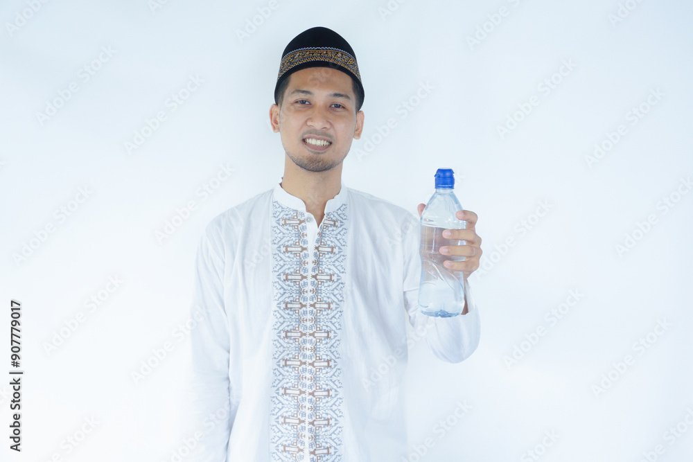 Moslem Asian man smiling happy while showing drinking plastic bottle Moslem Asian man smiling happy while showing drinking plastic bottle