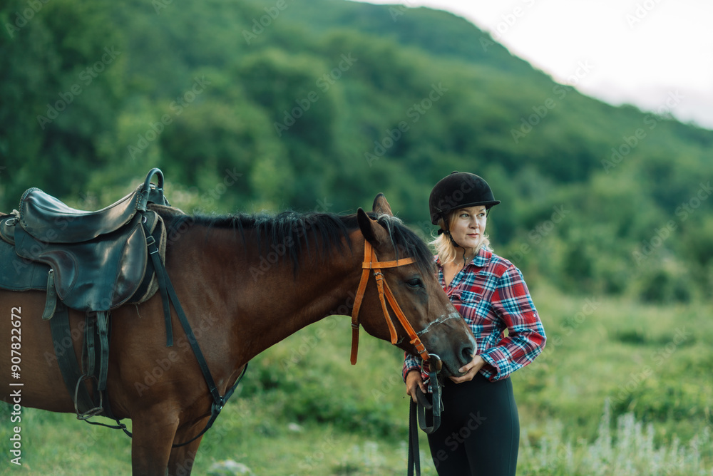 Obraz premium Happy blonde with horse in forest. Woman and a horse walking through the field during the day. Dressed in a plaid shirt and black leggings.