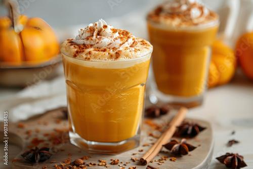 Delicious pumpkin smoothie with whipped cream on top. Garnished with cinnamon and spices on a cozy autumn background with pumpkins and autumn leaves photo