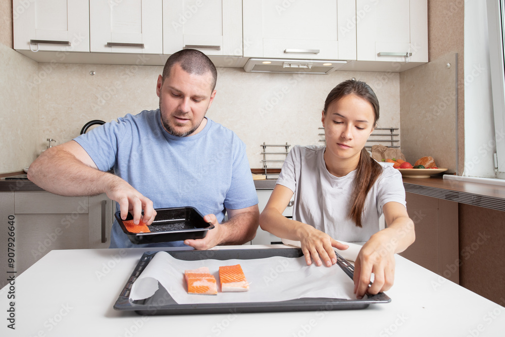 Teenage girl and father cooking fish together, preparing breakfast together, kitchen lifestyle fun Teenage girl and father cooking fish together, preparing breakfast together, kitchen lifestyle fun