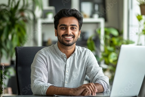 Smiling young Indian man sitting in the office at the desk and talking on a video call, making an online recording, conducting training remotely, Generative AI