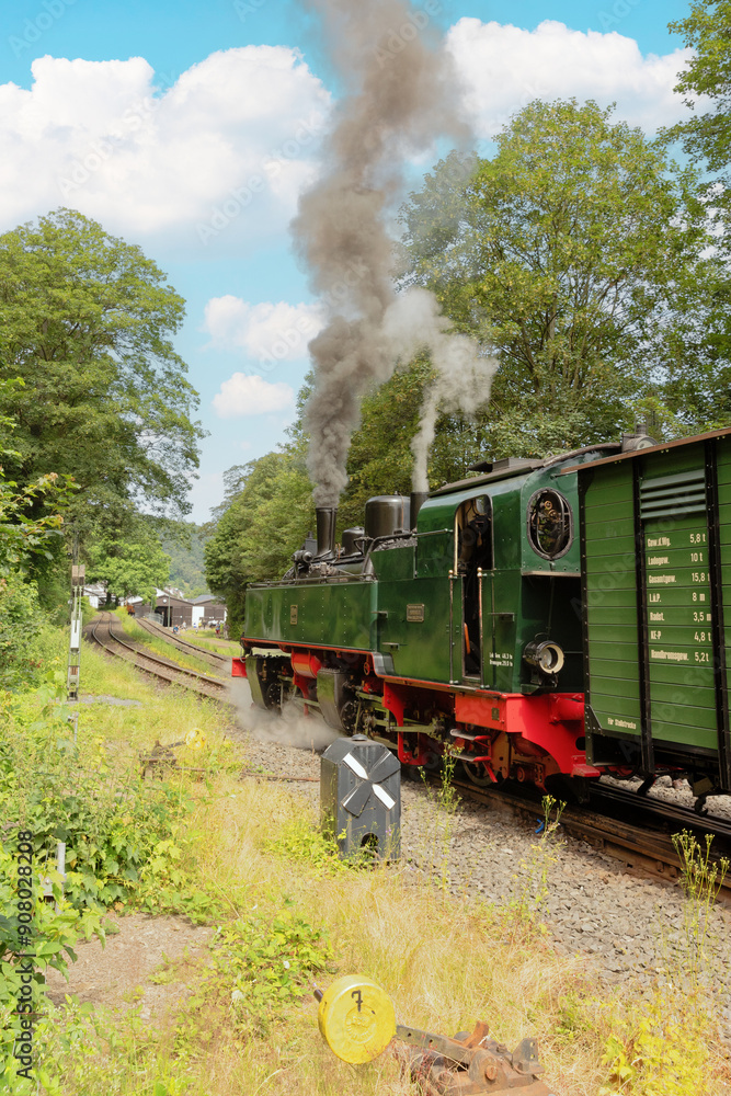 Obraz premium Alte Dampflok verlässt den Bahnhof