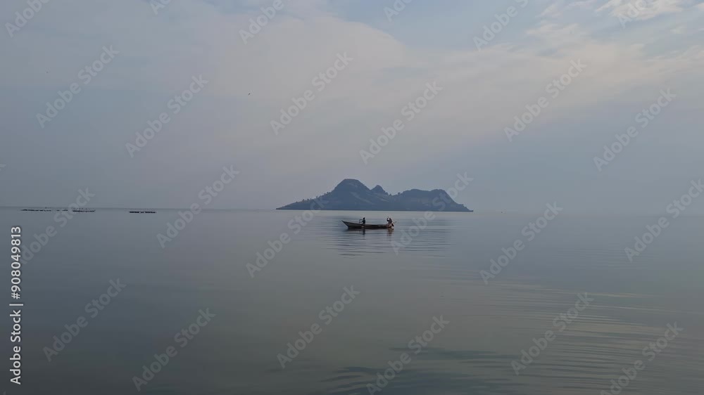 A small boat navigates the tranquil waters, heading towards a distant island on a misty, serene day. The image evokes a sense of peace, solitude, and the beauty of nature. A small boat navigates the tranquil waters, heading towards a distant island on a misty, serene day. The image evokes a sense of peace, solitude, and the beauty of nature.