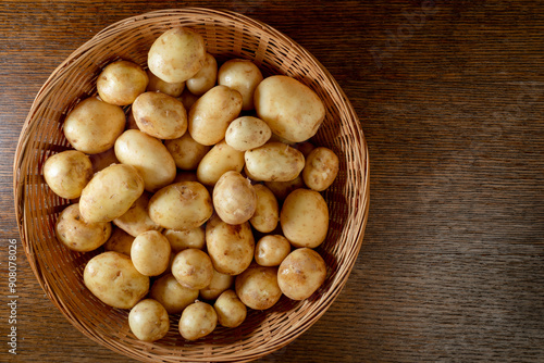 Fresh uncooked baby potatoes gemson variety grown in Norfolk UK in basket on wooden top. Top view. British product.